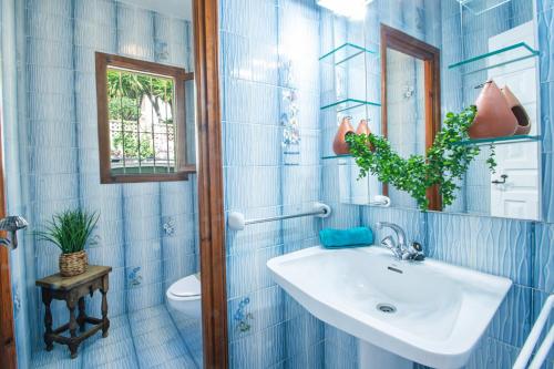 een blauw betegelde badkamer met een wastafel en een toilet bij Villa Sabine - PlusHolidays in Calpe