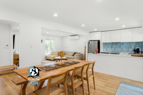 a kitchen and living room with a wooden table and chairs at Hampton's Style Holiday Retreat - close to the beach! in Encounter Bay