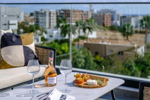 a table with two glasses and a bottle of wine at Noir Luxury Residences by Nomads in Limassol