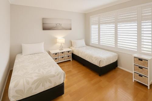 a bedroom with two beds and a window at Macs Manor in Dunsborough