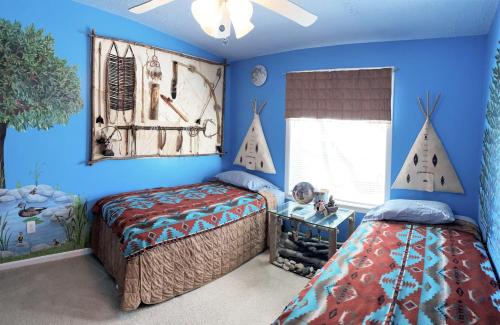 two beds in a bedroom with blue walls at Serendipity in Saint Ignace