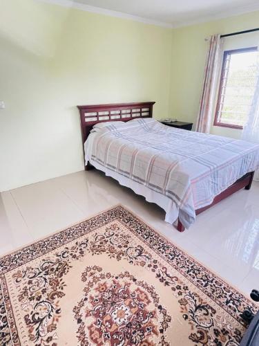 a bedroom with a bed and a rug on the floor at Spacious Farm House Natadola in Sigatoka