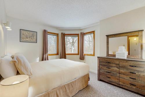a bedroom with a bed and a dresser and a mirror at Slopeside 4001 in Jay