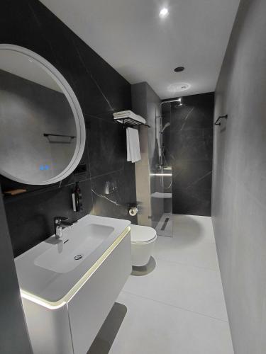 ein Badezimmer mit einem weißen Waschbecken und einer Toilette in der Unterkunft Hotel Meteo Kakheti in Telawi