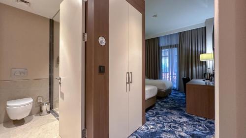 a bathroom with a toilet and a sink at Tbilisi Philharmonic Hotel by Mercure in Tbilisi City