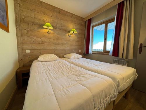 a bedroom with two beds and a window at Résidence Christiana 406 Clés Blanches Courchevel in La Tania