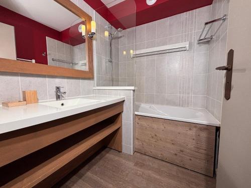 a bathroom with a sink and a bath tub at Résidence Christiana 406 Clés Blanches Courchevel in La Tania