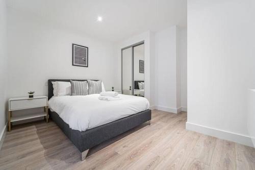 a white bedroom with a bed and a mirror at Contemporary Studio near NEC & Airport Free Parking in Olton