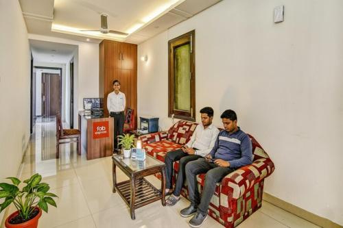 due uomini seduti su un divano in una sala d'attesa di Via Hemkunt Residency a Noida