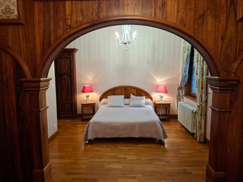Um quarto com um arco, uma cama e dois candeeiros. em Domaine de La Vitrolle em Limeuil