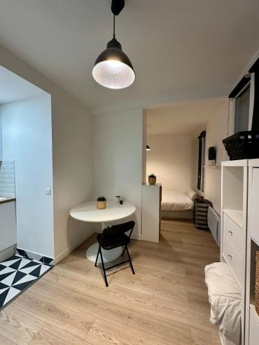 ein Wohnzimmer mit einem Tisch und ein Schlafzimmer in der Unterkunft Charming Studio - Monceau - Ternes in Paris