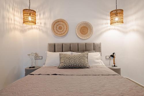 a bedroom with a bed with two baskets on the wall at Villa Anamnesia, Stelida Naxos in Stelida