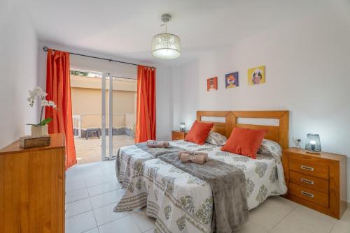 Un dormitorio con una cama con almohadas naranjas. en Brisas Chasna 2, en Adeje