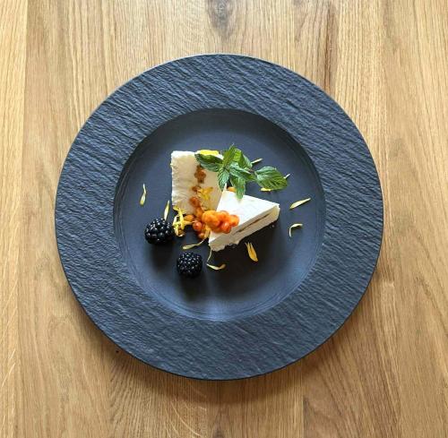 Un plato azul con un trozo de queso y fruta. en Hotel Thisted, en Thisted