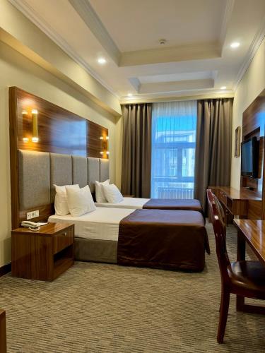 a hotel room with a bed and a window at Grand Hotel Eurasia in Almaty