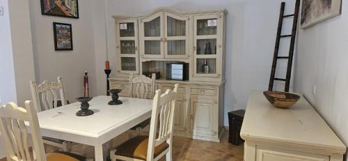 ein Esszimmer mit einem weißen Tisch und einem weißen Schrank in der Unterkunft La Senda del Lago in Córdoba
