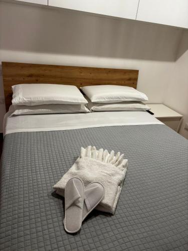 a bed with a pair of flip flops and a pair of shoes at Anxur Apartment in Terracina