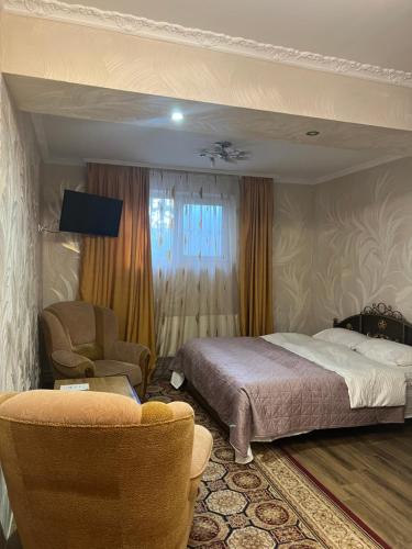 キシナウにあるGolden Roseのベッドと椅子のあるホテルの部屋