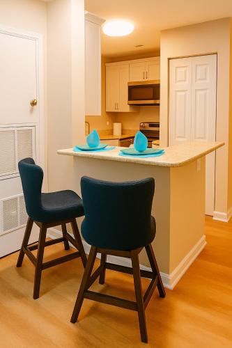 a kitchen with two chairs and a counter top at The Serene Uptown Flat in Charlotte