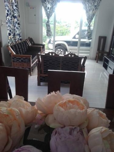 a living room with a table with flowers on it at MSM DIAMOND GUEST HOUSE lk in Ragama