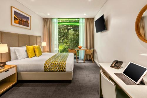 a hotel room with a large bed and a television at Quest Mounts Bay Road in Perth