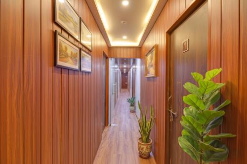 un corridoio con pareti rivestite in legno e una pianta di Via Arya Inn a Pune