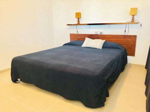 ロザスにあるGlobal Immo 2216 Puig Rom 68の壁にランプ2つが付いた客室の大型ベッド1台