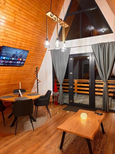 a dining room with a table and chairs and a table at Art A Cabin in Teşila