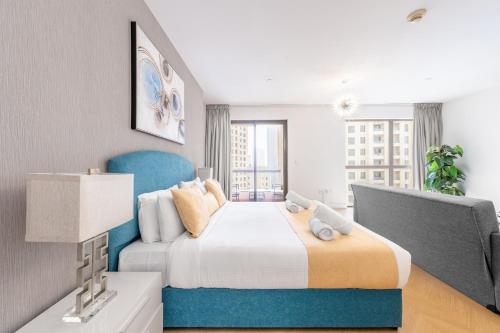 a bedroom with a large bed with a blue headboard at Luxury JBR · Marina View · 5* Beach Resorts Access in Dubai