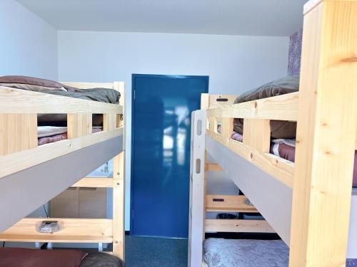 a room with two bunk beds and a blue door at Cate no mori - Vacation STAY 16675v in Shime