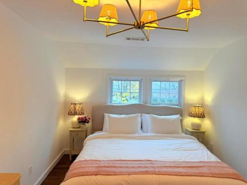 a bedroom with a large bed with two windows at Norwalk Retreat in Norwalk