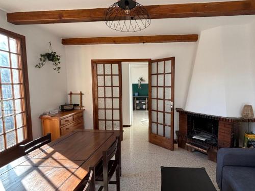Gîte Le Chicateou في لو ديفولي: غرفة معيشة مع طاولة ومدفأة