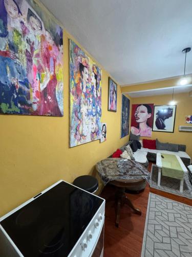 Una sala de estar con televisor de pantalla plana y cuadros en las paredes. en MM Apartman, en Foča