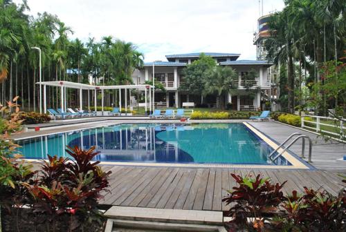 una piscina in un resort con sedie e alberi di Myanmar Life Hotel a Yangon