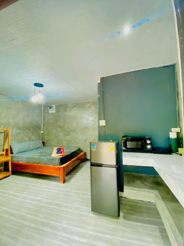 a room with a bed and a refrigerator in it at Baan Amila in Phra Ae beach