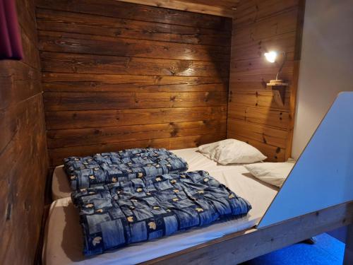 a bed in a room with a wooden wall at Vakantiepark Zwartemeer in Zwartemeer
