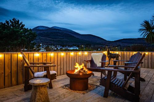 a patio with chairs and a fire pit at night at The Hikers House by House Hideaways in Newcastle