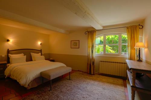 Un dormitorio con una cama y una ventana en La Treille Muscate, en Cliousclat