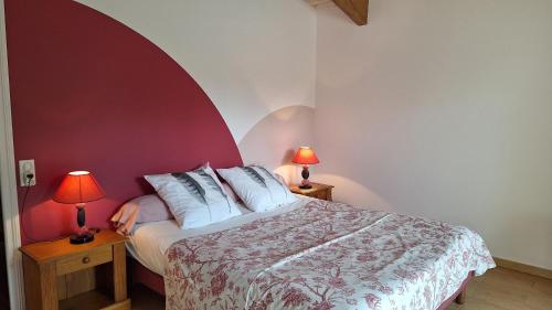 a bedroom with a bed with a red wall at Gîte les charrières in Pouzauges