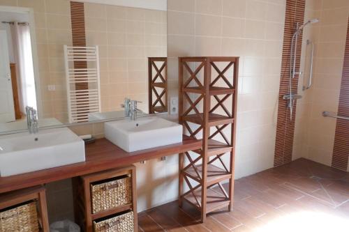 a bathroom with two sinks and a mirror at Gîte les charrières in Pouzauges