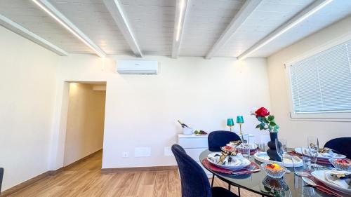 a dining room with a glass table and blue chairs at Bon Bon Suite by Ca-sa Check in Sottomarina