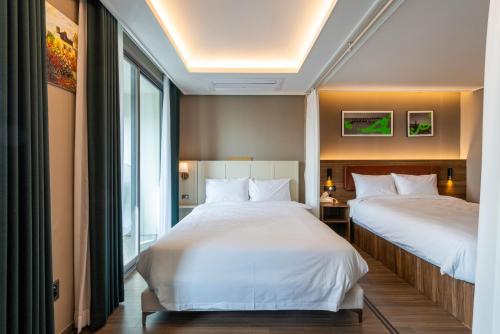 una camera d'albergo con due letti e una finestra di Bona Haeundae fantastic ocean view #Sea and Haeundae Gunam-ro# a Busan
