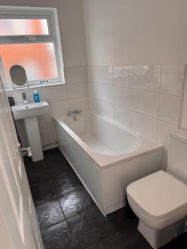 a bathroom with a tub and a toilet and a sink at Nobles Nest in Skegness