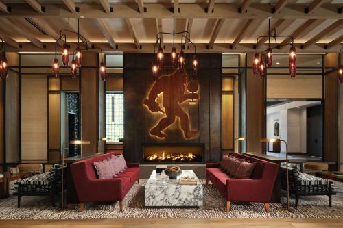 a living room with two red chairs and a fireplace at The SOMM Hotel & Spa, Autograph Collection in Woodinville