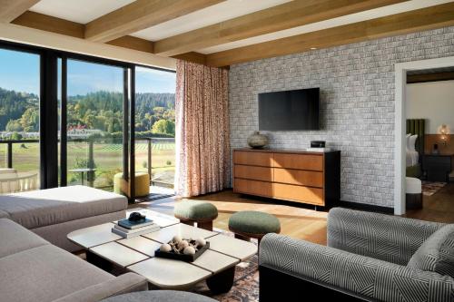 a living room with a couch and a tv at The SOMM Hotel & Spa, Autograph Collection in Woodinville