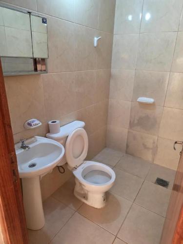 a bathroom with a toilet and a sink at Complejo Cambyreta Alojamiento temporario para 7 personas Encarnación Cerca de Playa San Jose in Cambyretá