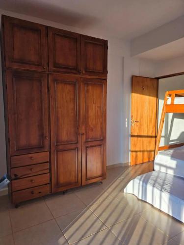 a bedroom with a bed and wooden cabinets at Complejo Cambyreta Alojamiento temporario para 7 personas Encarnación Cerca de Playa San Jose in Cambyretá