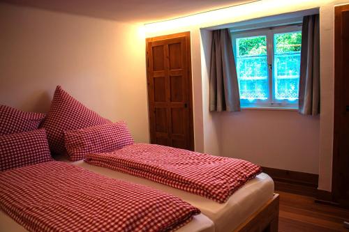 1 dormitorio con 2 camas con sábanas rojas y blancas a cuadros en Fewo Kupferschmid, en Sasbachwalden