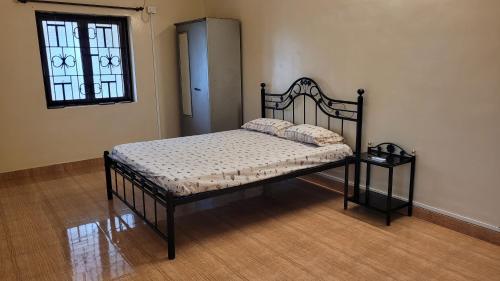 a bedroom with a bed in a room with a window at Ferns Cottage in Calangute