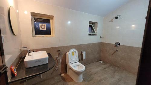 a bathroom with a toilet and a sink at Ferns Cottage in Calangute